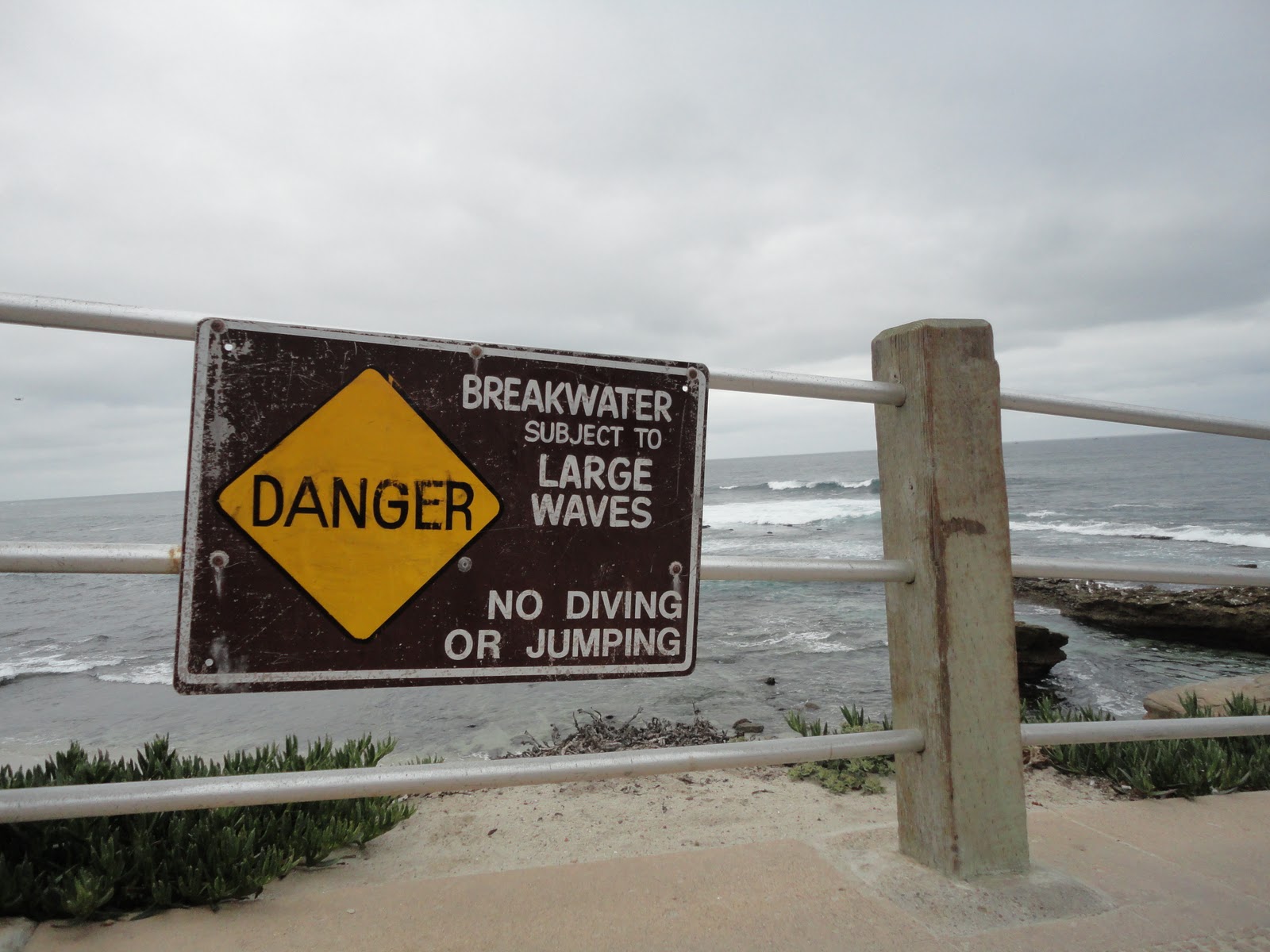 Sign says BREAKWATER SUBJECT TO LARGE WAVES NO DIVING OR JUMPING